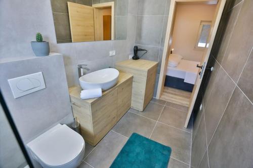 een kleine badkamer met een toilet en een wastafel bij VILLA ENJOY LUX private heated pool in Split in Split