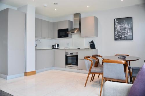 a kitchen and dining room with a table and chairs at Sanctum Belsize Road in London