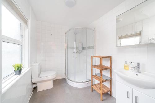 uma casa de banho com um chuveiro, um WC e um lavatório. em Soho & Covent Garden Apartment, Sleeps 3 em Londres