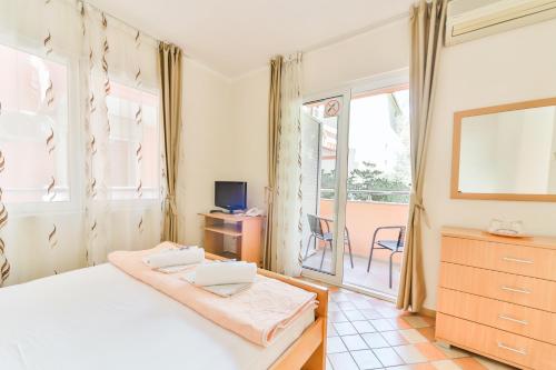 a bedroom with a white bed and a balcony at Garni Hotel Koral in Budva