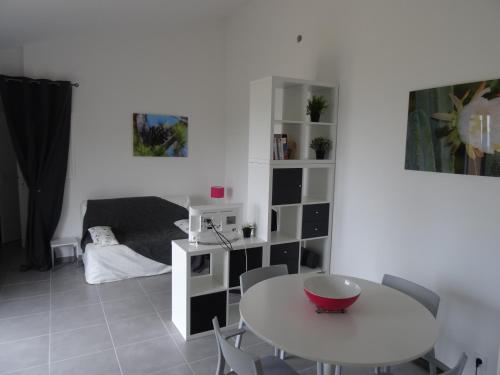une chambre blanche avec une table et une chambre dans l'établissement Maison calme très belle vue Lavandou, au Lavandou