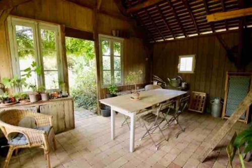 une cuisine avec une table et des chaises dans une pièce dans l'établissement « Beslétoile » au cœur de la nature, à Beslé