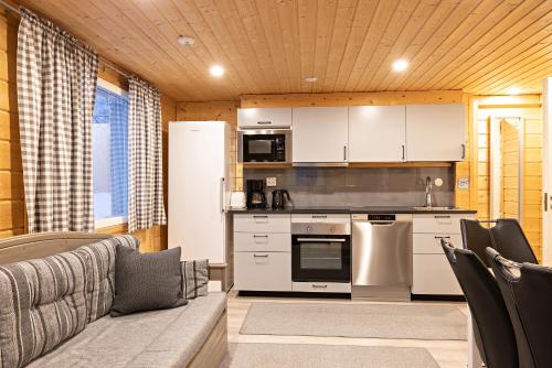 a living room with a couch and a kitchen at Arctic River Resort in Ivalo