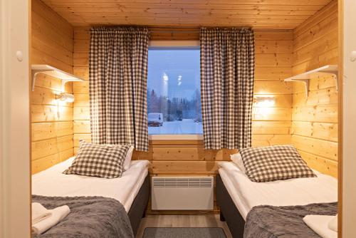 a room with two beds in a log cabin at Arctic River Resort in Ivalo