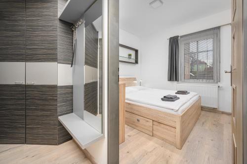a small bedroom with a bed and a window at Apartmá SunGarden Liberec in Liberec