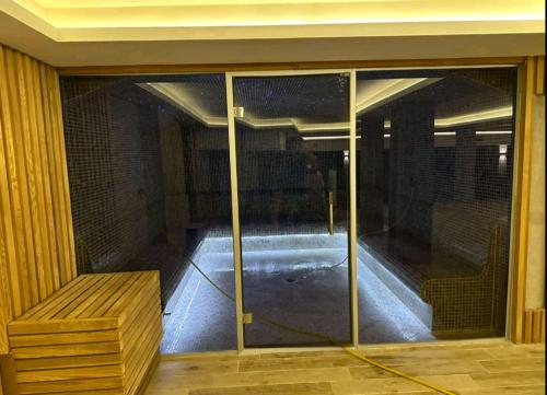 a glass door with a bench in a room at Apartman D&V Milmari Resort S10 in Kopaonik