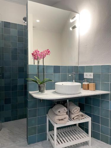 a bathroom with a sink and a vase of flowers at Casa Arcadia in Córdoba