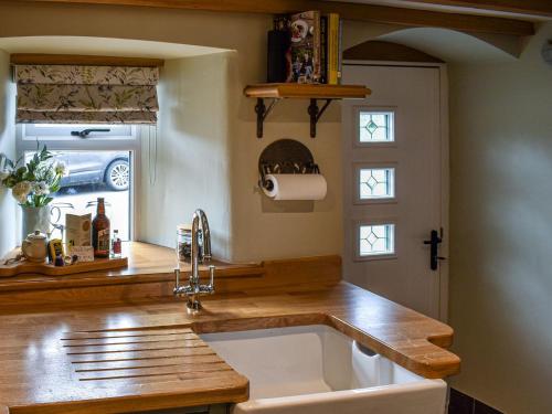 a kitchen with a sink and a counter top at Johnsons Cottage - Uk39727 in Taddington
