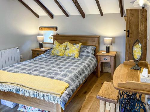 a bedroom with a bed with two tables and two lamps at Johnsons Cottage - Uk39727 in Taddington