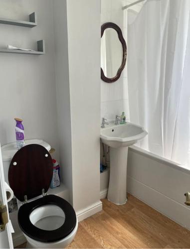a bathroom with a black toilet and a sink at Family Apartment in London Wi-Fi and free parking in Dagenham