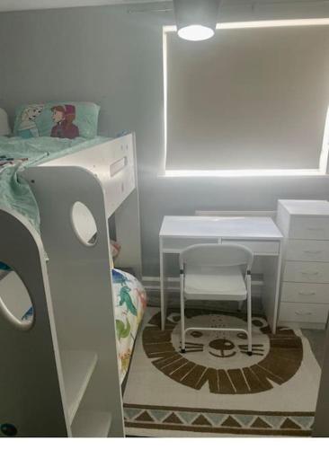 a bedroom with a bed and a desk and a chair at Family Apartment in London Wi-Fi and free parking in Dagenham