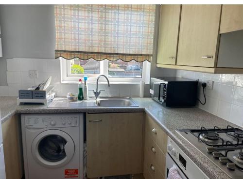 una cucina con lavatrice e lavandino di Family Apartment in London Wi-Fi and free parking a Dagenham