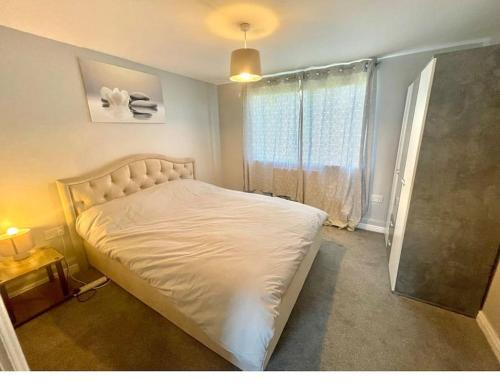 a bedroom with a white bed with a window at Family Apartment in London Wi-Fi and free parking in Dagenham