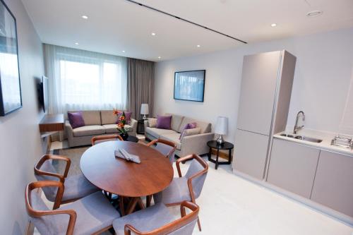 a living room with a table and chairs at Sanctum Belsize Road in London