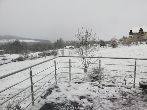 a fence covered in snow next to a field at Lipnohaus in Horní Planá