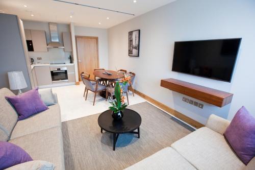 a living room with a couch and a table at Sanctum Belsize Road in London