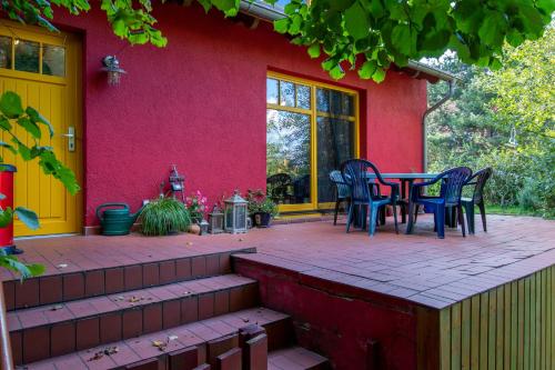 eine Terrasse mit einem Tisch und Stühlen vor einem roten Haus in der Unterkunft Ferienhaus Göhren-Lebbin in Göhren-Lebbin