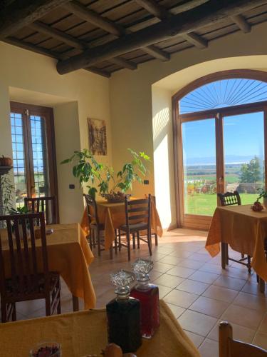 a dining room with tables and a large window at Antico Casale Edifizio in Viterbo