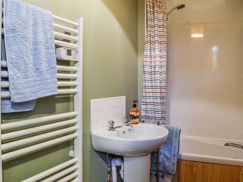 La salle de bains est pourvue d'un lavabo et d'une baignoire. dans l'établissement Kirk Wynd Cottage, à Kirriemuir