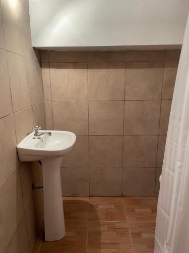 y baño con lavabo blanco y ducha. en Departamento Loft hasta 10 personas en Paraná