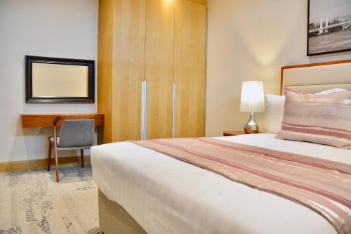 a hotel room with a bed and a desk at Sanctum Belsize Road in London