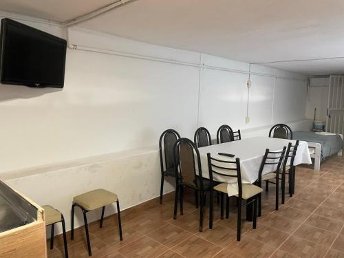 um quarto com uma mesa e cadeiras e uma televisão de ecrã plano em Departamento Loft hasta 10 personas em Paraná