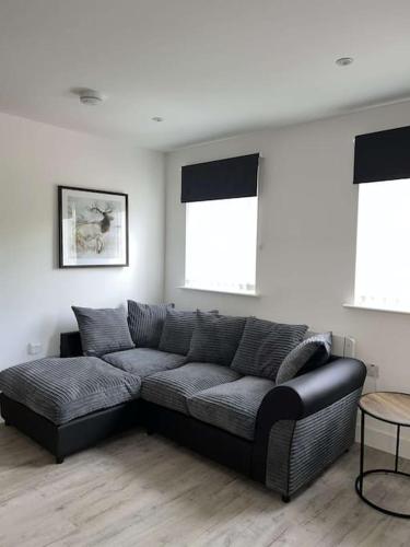 czarna kanapa w salonie z dwoma oknami w obiekcie Lovely one bed, open plan studio apartment. w mieście Culloden