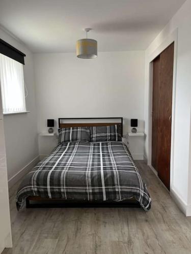 sypialnia z łóżkiem z kocem w kratę w obiekcie Lovely one bed, open plan studio apartment. w mieście Culloden