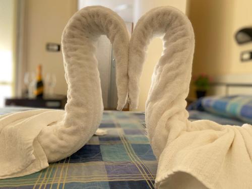two towels shaped like swans laying on a bed at Hotel Baltic in Cesenatico