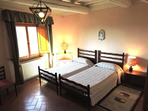 フィエーゾレにあるアグリツーリズモ モンテレージのベッドルーム1室(ベッド2台、窓付)