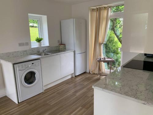 a kitchen with a washing machine and a sink at North View Cottage next to Hadrian's Wall in Gilsland