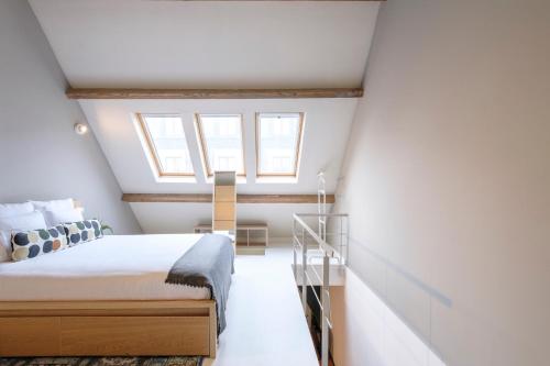 ブリュッセルにあるSplendide Duplex proche de la Grand-Placeの屋根裏のベッドルーム(ベッド1台、窓付)