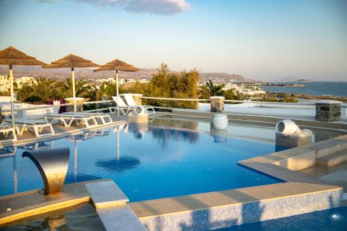 una piscina con sedie e ombrelloni in un resort di Kavuras Village ad Agios Prokopios