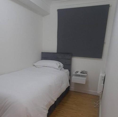 a bedroom with a bed and a black board on the wall at Lovely 2 bedroom Flat with Free Parking in New Southgate