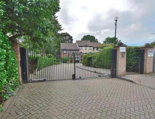 a black metal gate with a brick driveway at Lovely 2 bedroom Flat with Free Parking in New Southgate