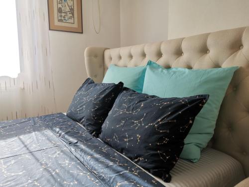 een bed met zwarte kussens en blauwe kussens bij Coffee Residence 1 in Boekarest