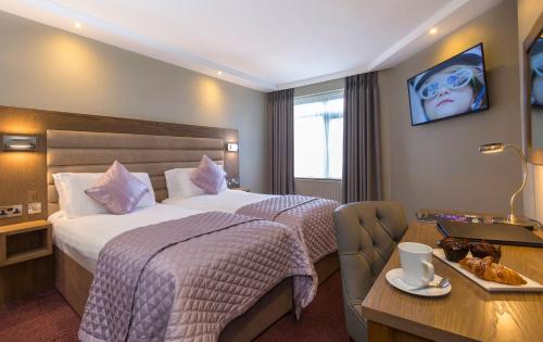 a hotel room with a large bed and a desk at Limerick City Hotel in Limerick