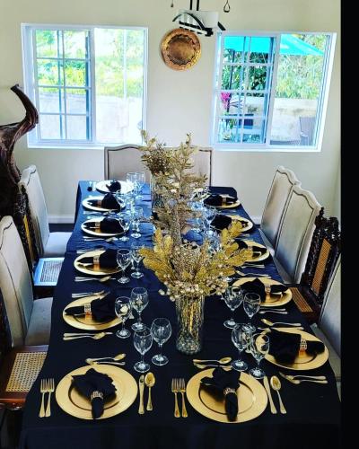 a long dining table with a blue table cloth and glasses at Blue Paloma Bed & Breakfast in Lucea