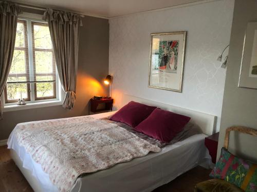 um quarto com uma cama grande e almofadas roxas em Villa Rørvik em Svelvik