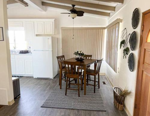 eine Küche mit einem Tisch und Stühlen sowie einem weißen Kühlschrank in der Unterkunft Joshua Tree National Park - Cozy Palms Getaway in Twentynine Palms