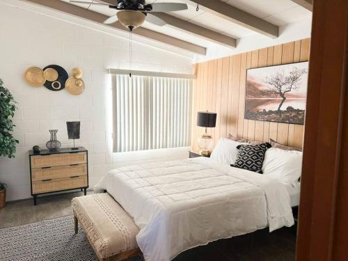 1 dormitorio con cama blanca y ventilador de techo en Joshua Tree National Park - Cozy Palms Getaway, en Twentynine Palms