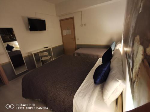ローマにあるDomus Viatorisのホテルルーム(青い枕付きのベッド付)