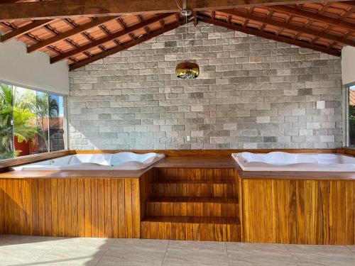 a jacuzzi tub in a room with a brick wall at Pousada Encanto dos Anjos in Pirenópolis