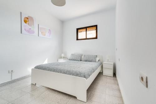 - une chambre blanche avec un lit et une fenêtre dans l'établissement Home2Book Lovely Beachfront Apt Arinaga Green, à Arinaga