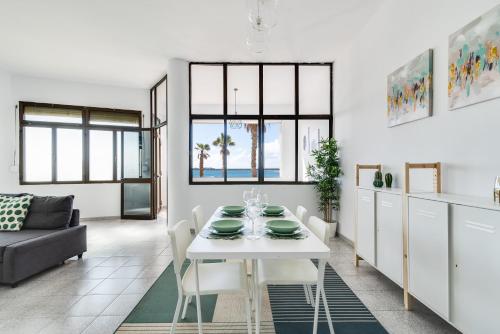 - une salle à manger blanche avec une table et des chaises blanches dans l'établissement Home2Book Lovely Beachfront Apt Arinaga Green, à Arinaga