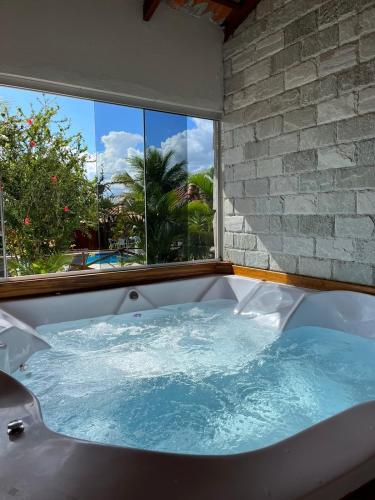 a large bath tub in a room with a window at Pousada Encanto dos Anjos in Pirenópolis