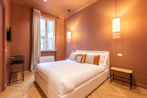a bedroom with a white bed and a window at DH Rooms Spiga in Milan