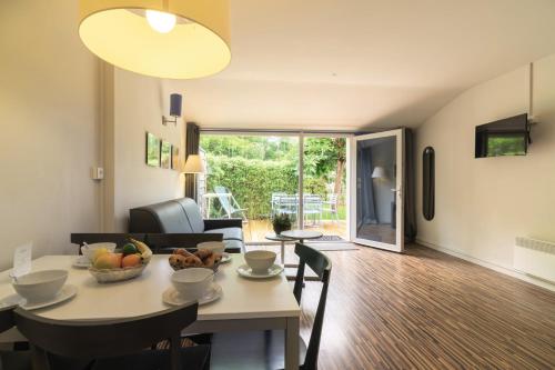 a dining room and living room with a table and chairs at Belambra Clubs La Palmyre - Les Mathes in Les Mathes