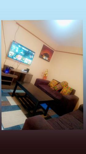 een woonkamer met een bank en een tafel bij Sassy's Hub in Kakamega