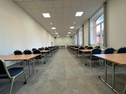 una sala de conferencias vacía con mesas y sillas en Penzion Burra en Vrútky